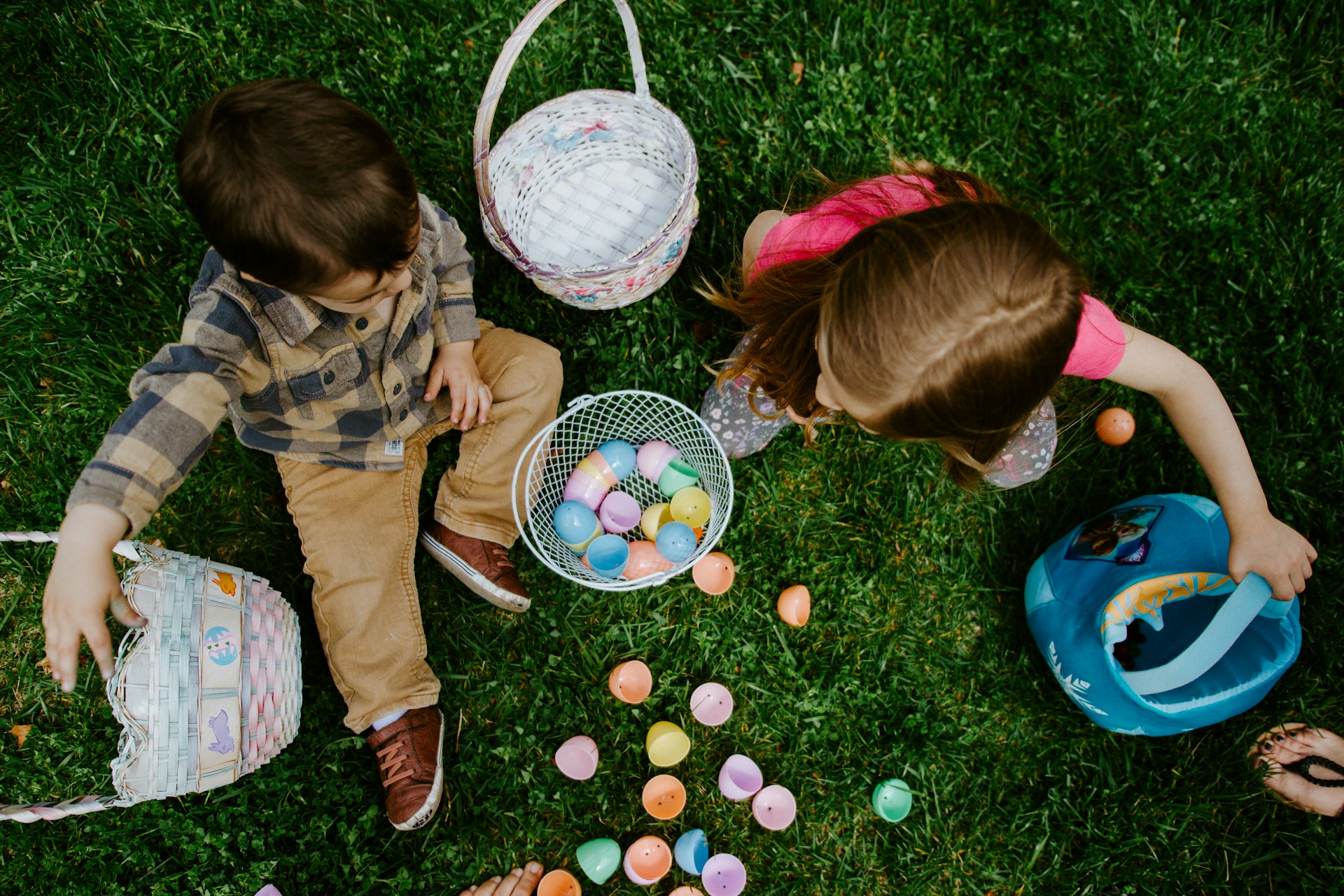 Two Kids with Plastic Easter Eggs and Baskets All Around Them